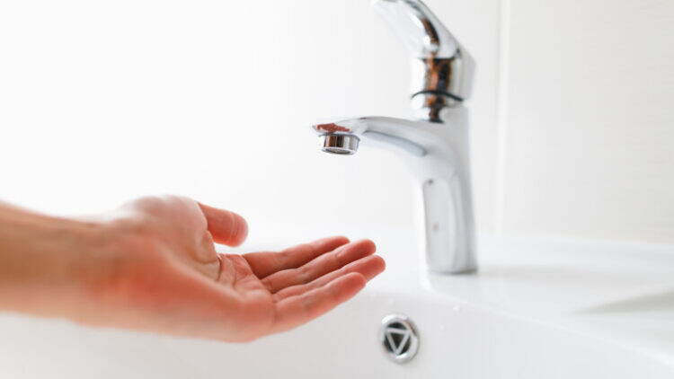 hand under faucet without water, close-up view