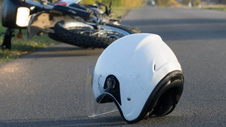 Photo of helmet and motorcycle on road, the concept of road accidents