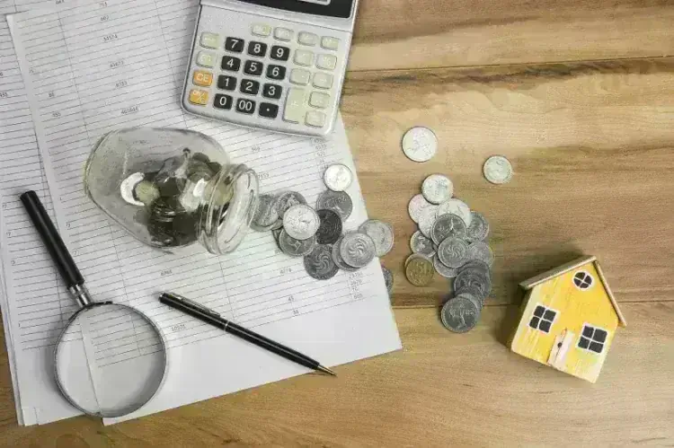 house model with coins on document